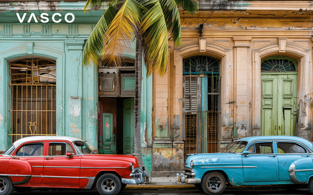 Straße in Havanna, Kuba, mit bunten Autos, die vor bunten Häusern geparkt sind.