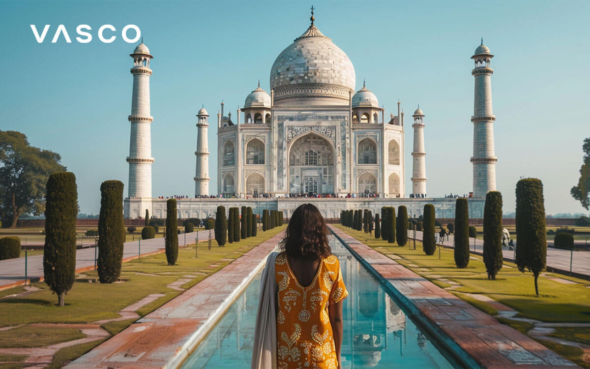 Eine Frau steht vor dem Taj Mahal in Indien.