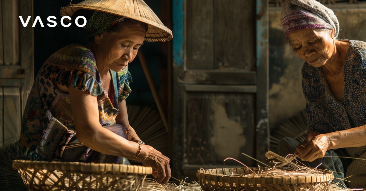 Zwei vietnamesische Frauen bei der Arbeit mit Körben in einem Haus, die man bei einem Vietnamurlaub im Oktober sieht.