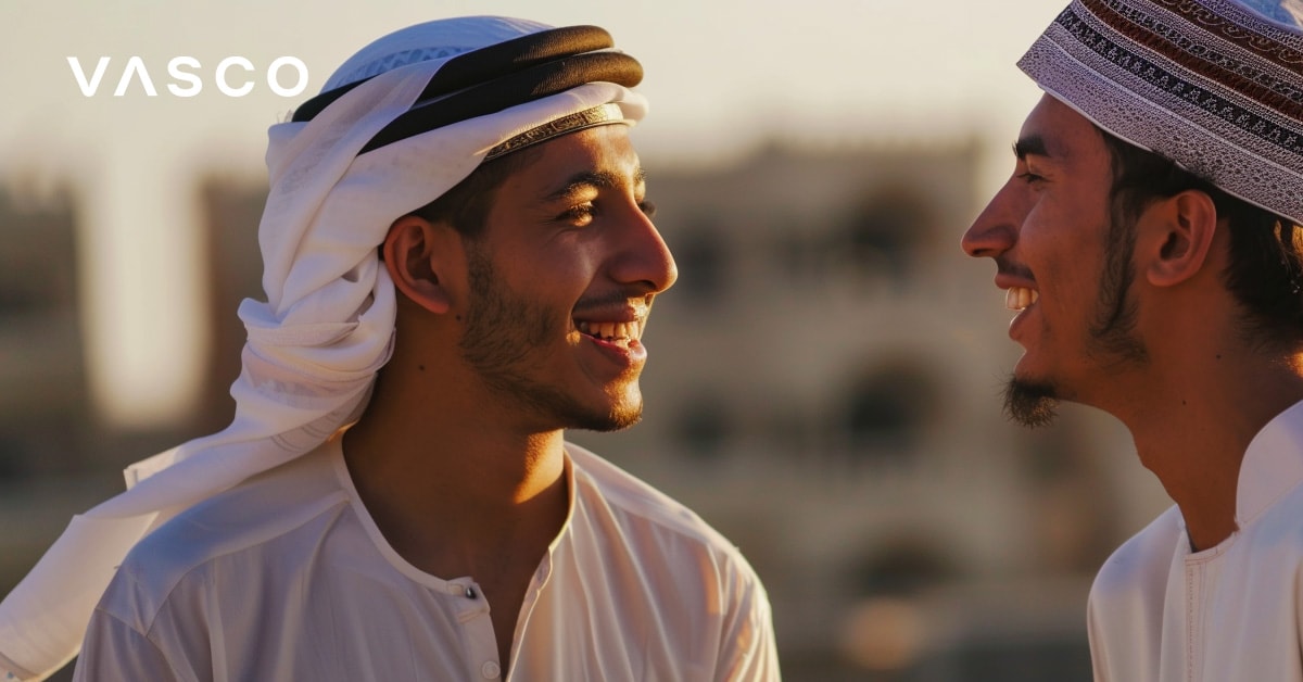 Zwei Männer in Arabischer Kleidung schauen sich lächelnd an; sie sagen auf diese Weise Hallo