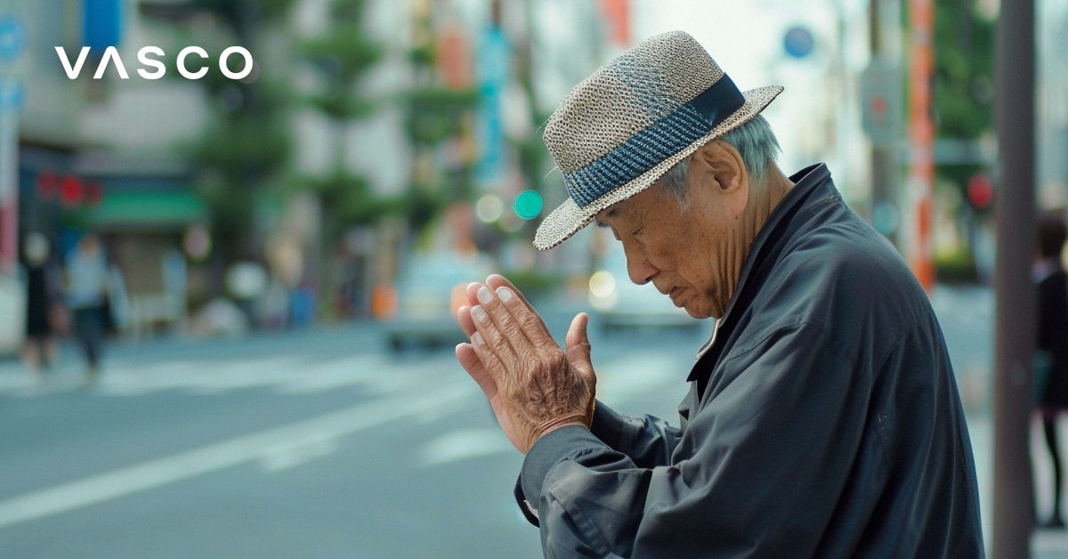 Ein älterer Mann legt die Hände aneinander und senkt den Kopf; auf diese Weise begrüßt man sich in Japan