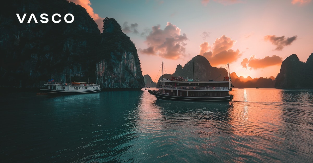 Boote in der Halong-Bucht bei Sonnenuntergang, die zeigen, dass Vietnam im Oktober ein idealer Urlaubsort mit warmen Temperaturen ist.