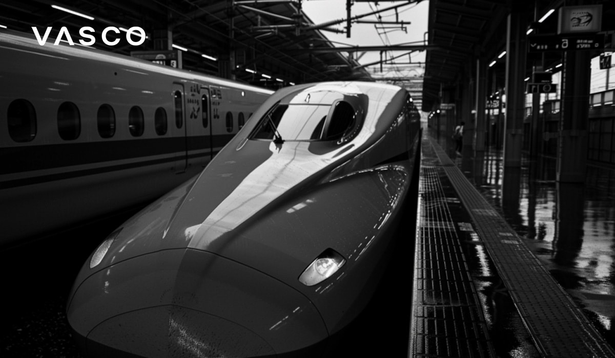 Ein japanischer Hochgeschwindigkeitszug steht bereit, um den Bahnsteig zu verlassen. Das Foto ist in Schwarz-Weiß.