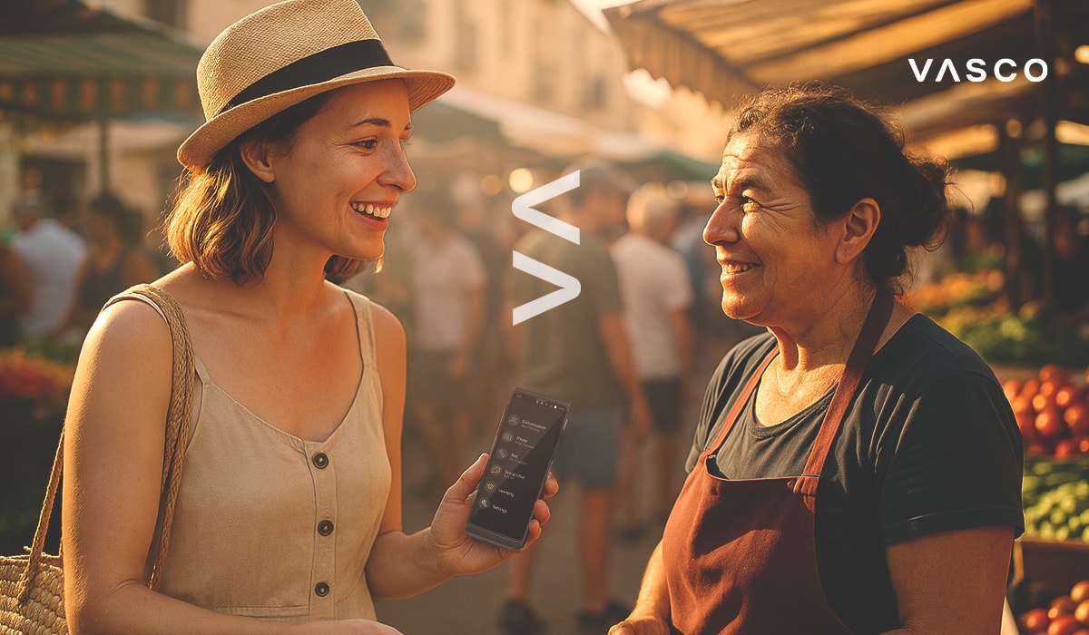 Eine Touristin steht mit einer einheimischen Verkäuferin auf einem Markt und hält einen Vasco Translator Sprachübersetzer in der Hand.