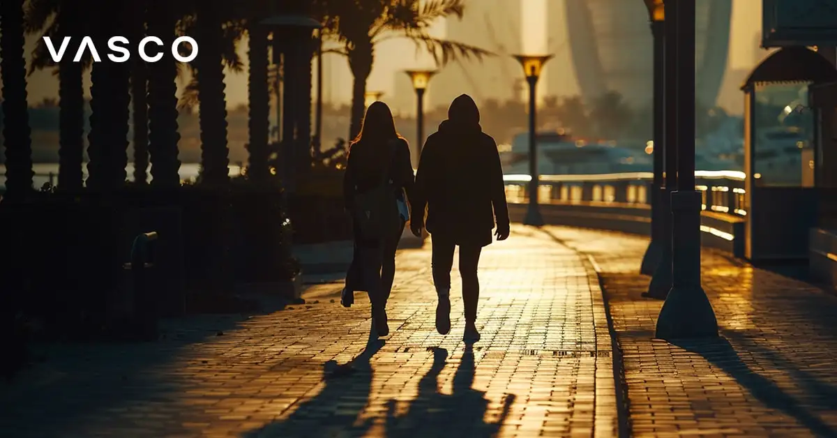 Ein Paar spaziert entlang der Dubai Marina Promenade bei Sonnenuntergang.