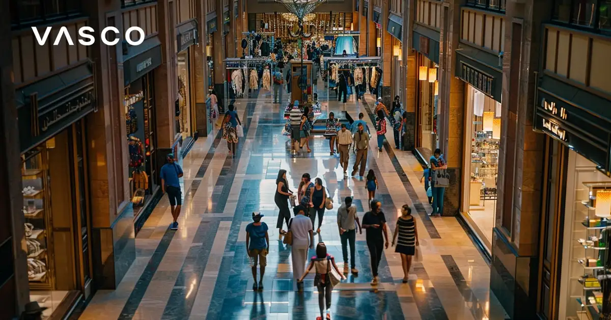 Indoor-Einkaufszentrum in Dubai mit vielen Menschen und Luxusgeschäften.