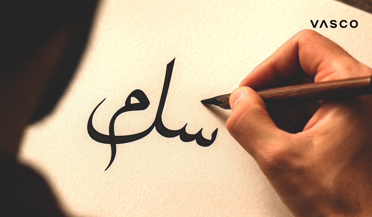 Arabische Schrift wird mit einem Stift auf ein Stück Papier geschrieben