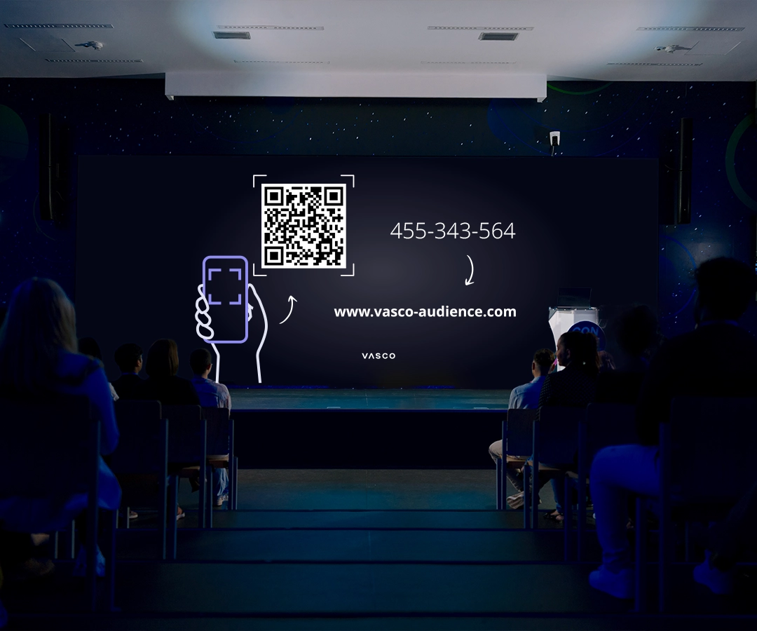 Auf einem großen Bildschirm in einem Konferenzraum wird angezeigt, wie Zuhörer einer Sitzung mit Vasco Audience beitreten können.