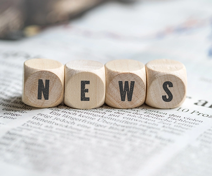 Blöcke mit dem Wort „NEWS“, die auf einer Zeitung liegen.